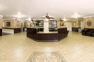 Front lobby with tile entry, ceiling fans, and reception desk.