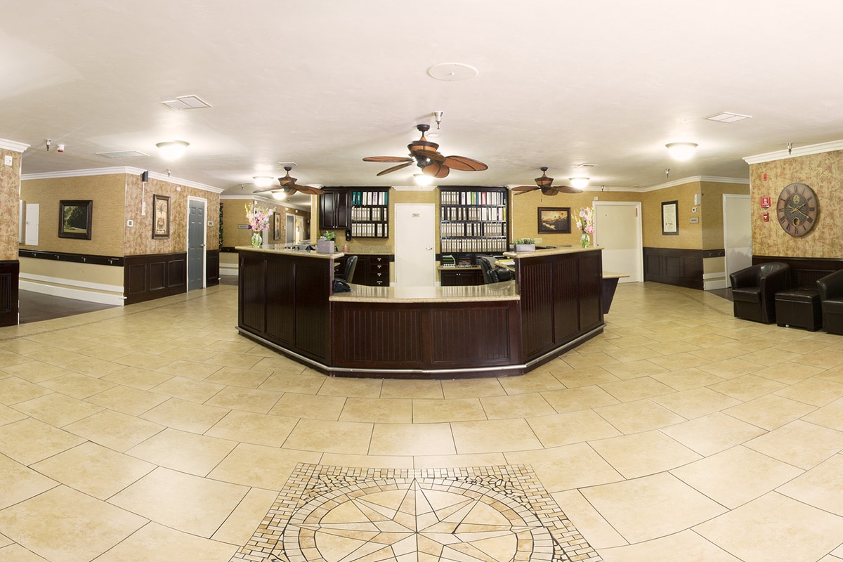 Front lobby with tile entry, ceiling fans, and reception desk.
