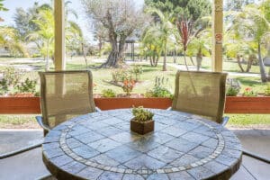 Outside round table on the patio with palm trees in the background.