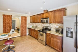 Occupational therapy gym with full kitchen including refrigerator, oven, sink, and microwave.