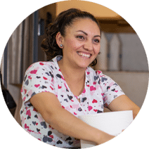 smiling woman holding cleaning supplies