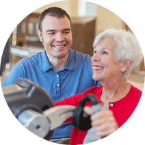 smiling rehab nurse assisting an elderly resident with an arm exercise
